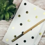 a notepad with a pen and a potted plant